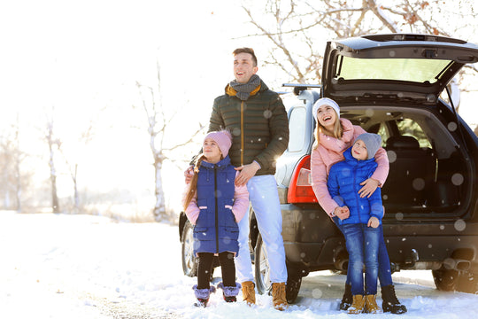 family with car in snow road trip travel organization